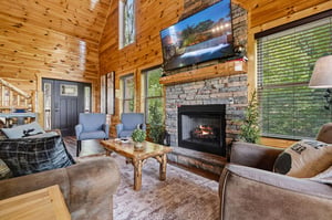 Sink into plush seating in this inviting living room, where natural wood and a cozy stone fireplace create your perfect mountain retreat.