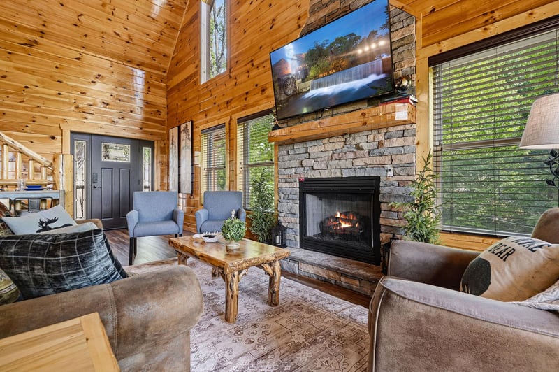 Sink into plush seating in this inviting living room, where natural wood and a cozy stone fireplace create your perfect mountain retreat.