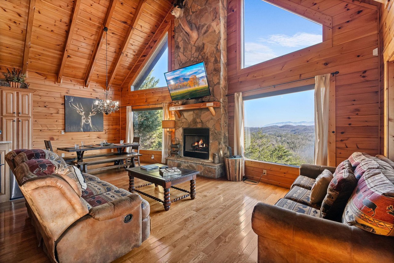 Living room with stone fireplace and big window views