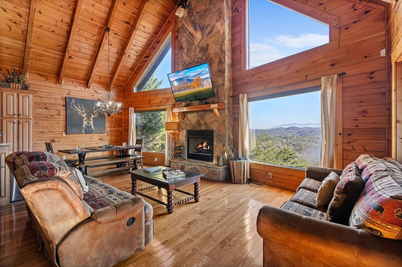 Living room with stone fireplace and big window views