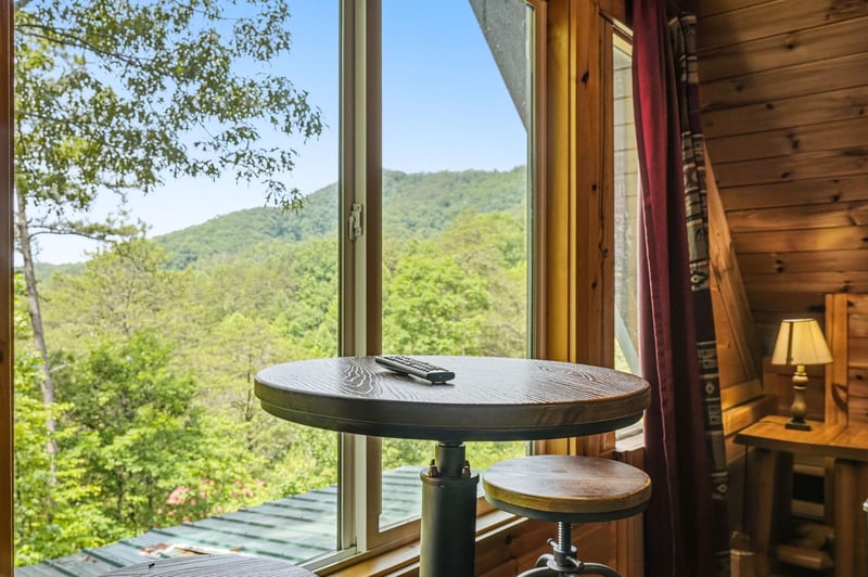 Imagine mornings at this cozy windowside table, sipping coffee while taking in sweeping mountain views. The lush green forest unfolds before you, offering a peaceful, private escape into nature.