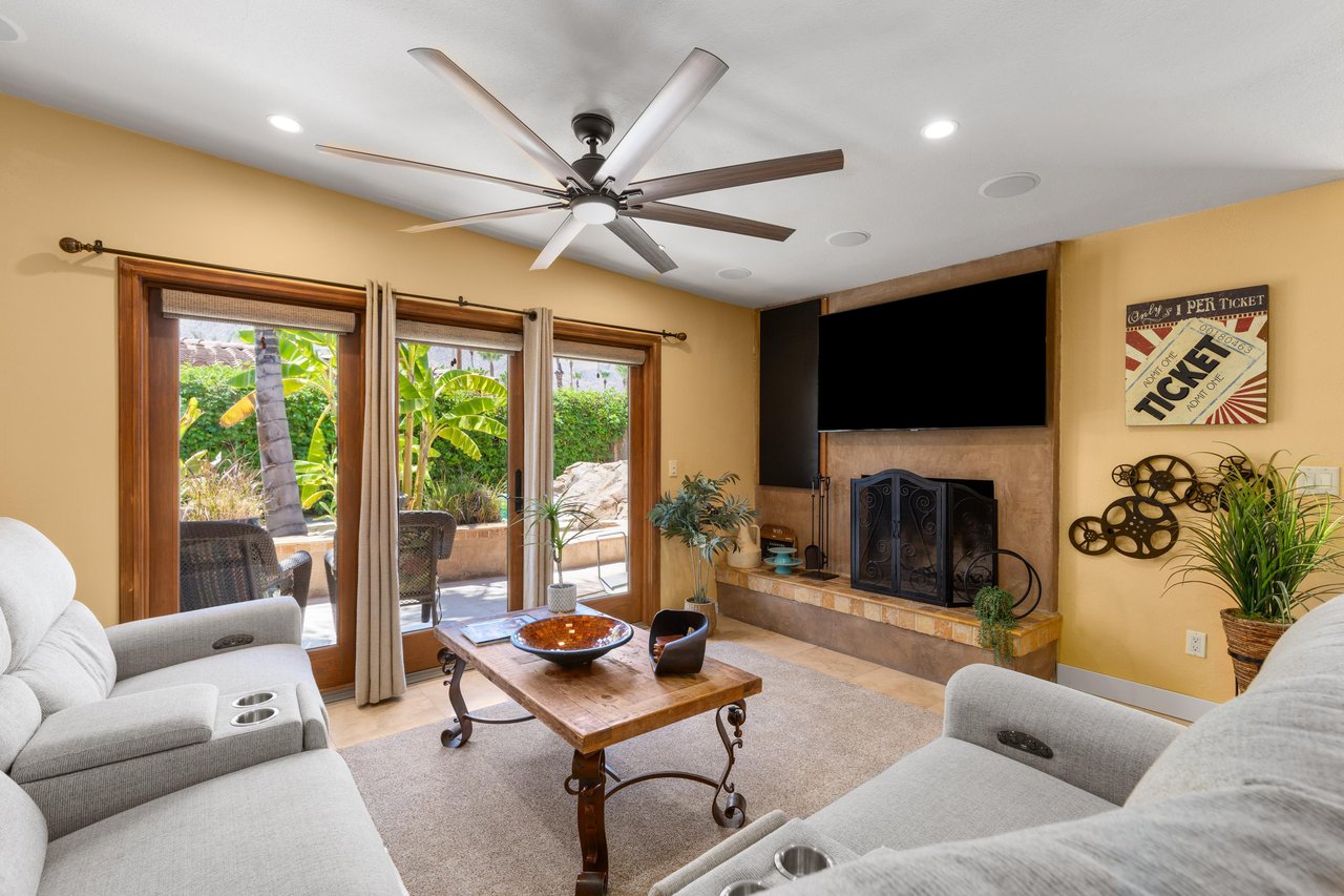 Flatscreen TV, patio access, and ample seating.