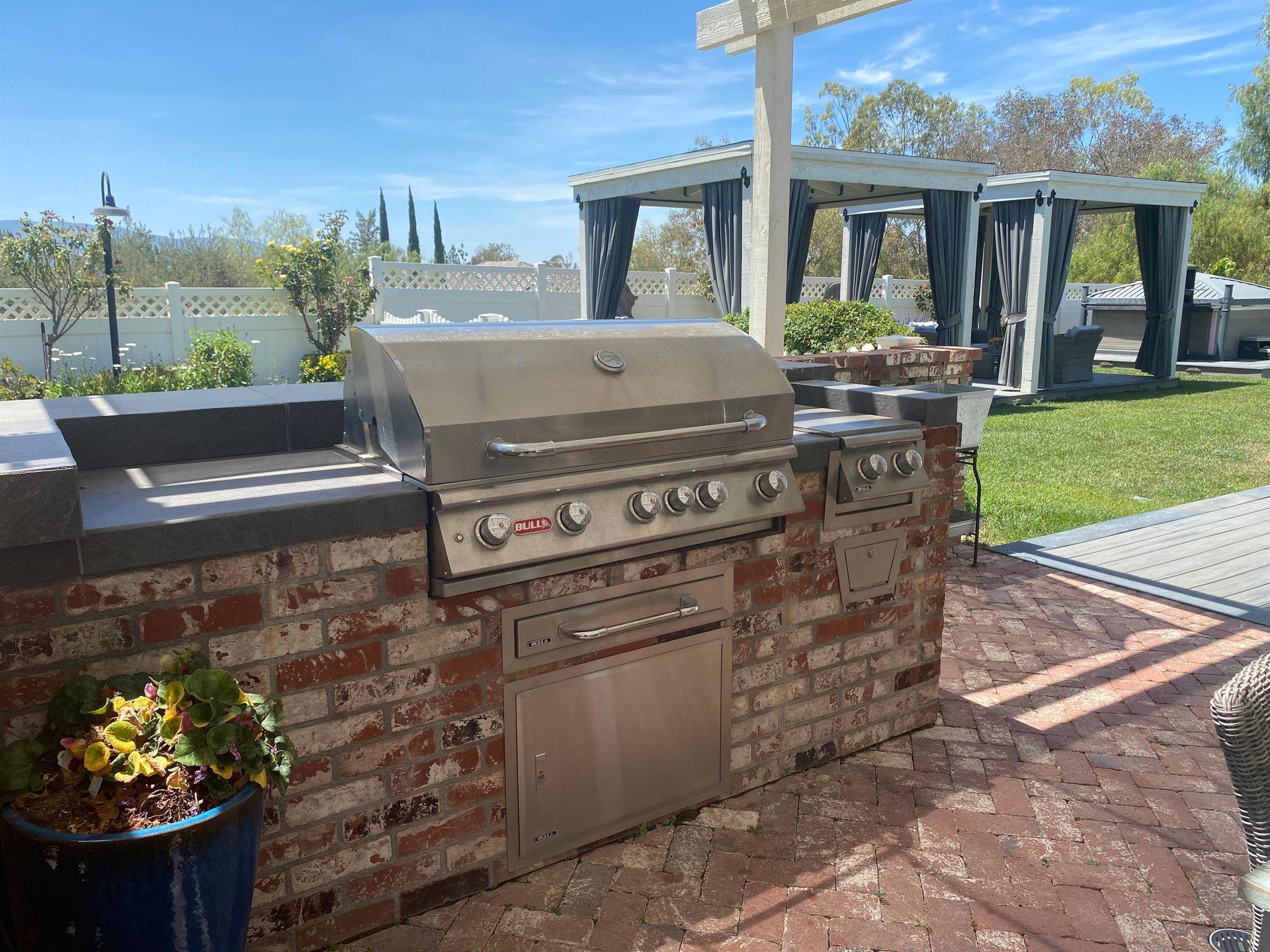 Follow the garden path to French doors and an inviting outdoor dining area with a BBQ grill.