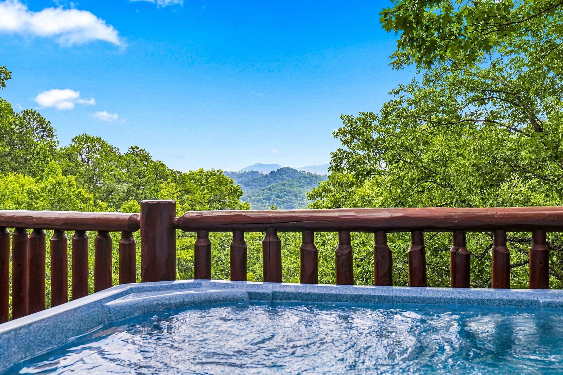 Soak away your cares with sweeping mountain views stretching into the distance, framed by lush green trees and endless blue skies.