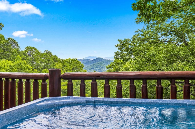 Soak away your cares with sweeping mountain views stretching into the distance, framed by lush green trees and endless blue skies.