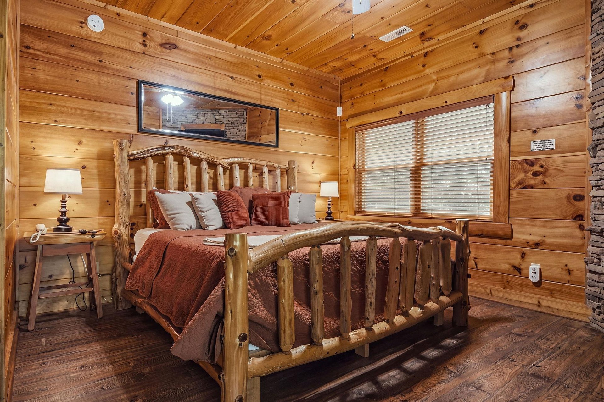 Drift off in your rustic log bed surrounded by warm woodpaneled walls, natural light, and the cozy mountain charm that makes this bedroom a peaceful retreat.