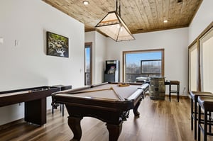 Challenge friends to pool or unwind with mountain views in your private game room featuring rustic wood ceilings.
