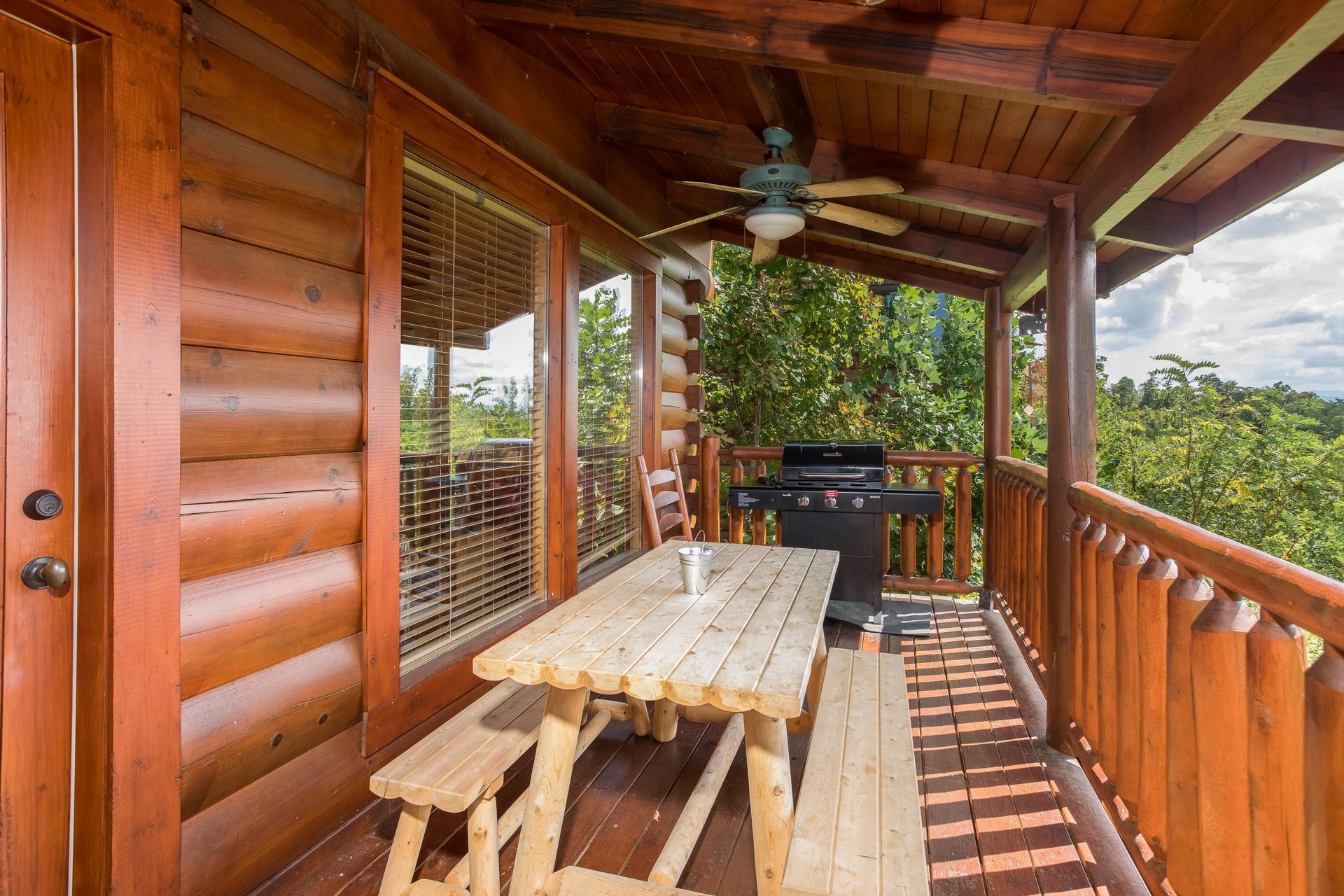 Picnic table with grill on a covered deck at Graceland, a 4bedroom cabin rental located in Pigeon Forge