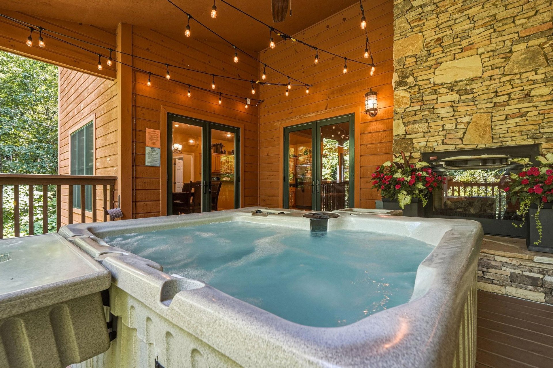 Slip into your private hot tub under string lights and mountain air, surrounded by warm wood and stone—a perfect spot to unwind after exploring the area.