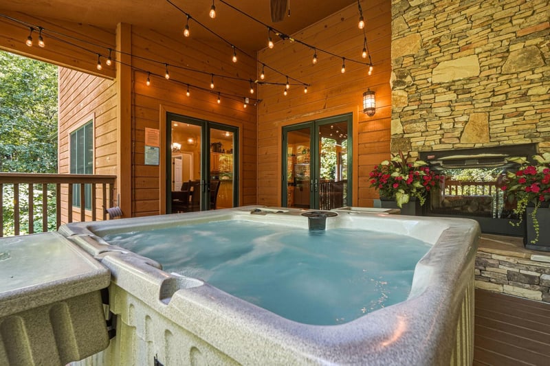 Slip into your private hot tub under string lights and mountain air, surrounded by warm wood and stone—a perfect spot to unwind after exploring the area.