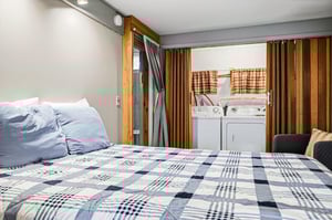 Sink into crisp blue linens in your cozy bedroom, where clever design places laundry right at your fingertips for ultimate convenience.