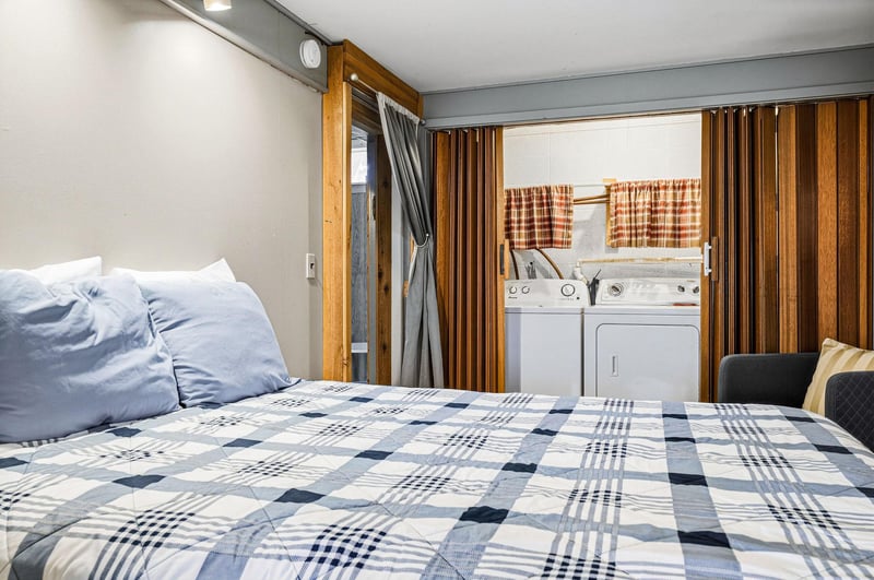 Sink into crisp blue linens in your cozy bedroom, where clever design places laundry right at your fingertips for ultimate convenience.