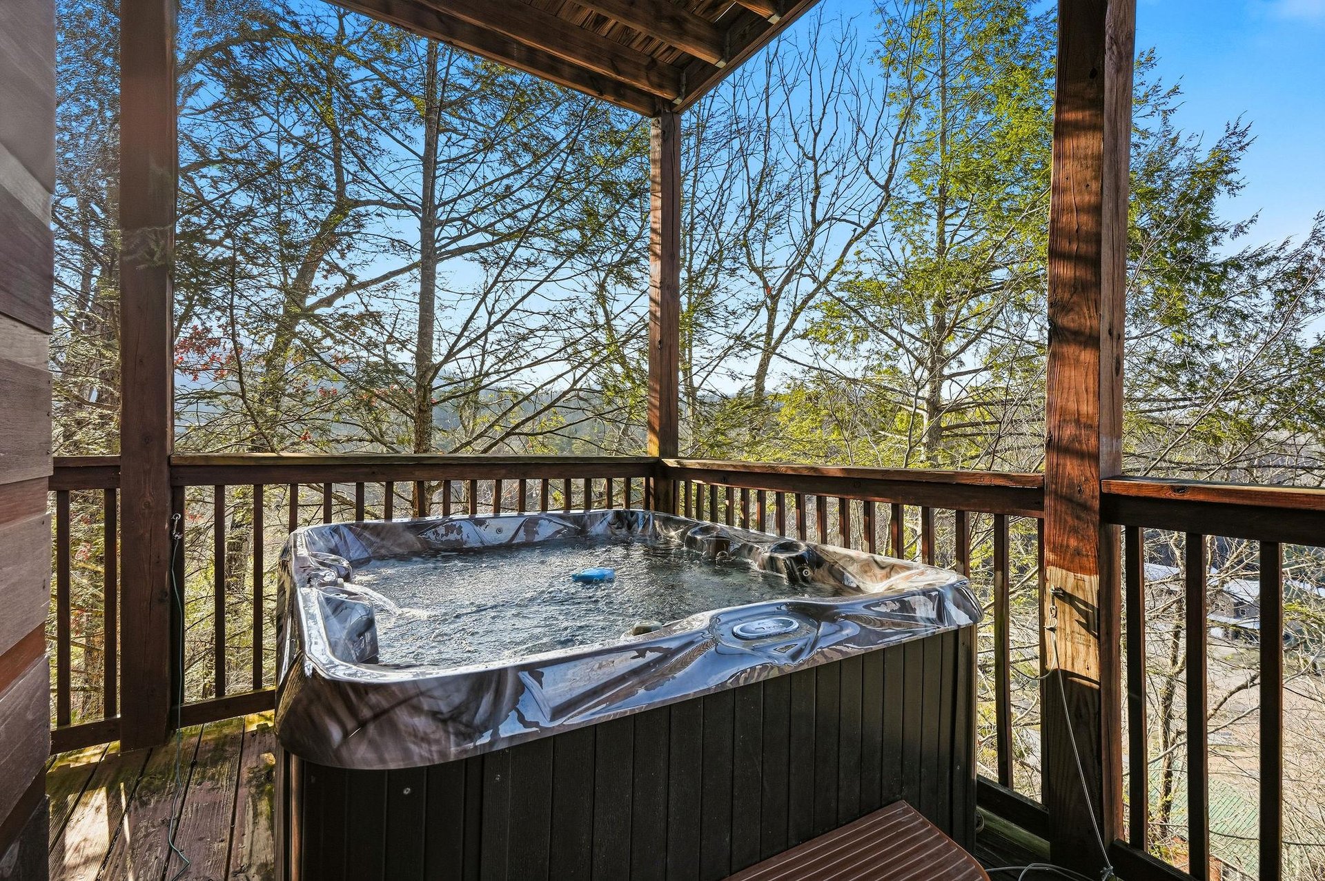 Soak in your private hot tub while taking in sweeping forest views from this peaceful covered deck.