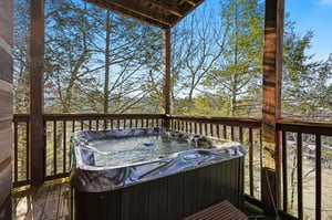 Soak in your private hot tub while taking in sweeping forest views from this peaceful covered deck.