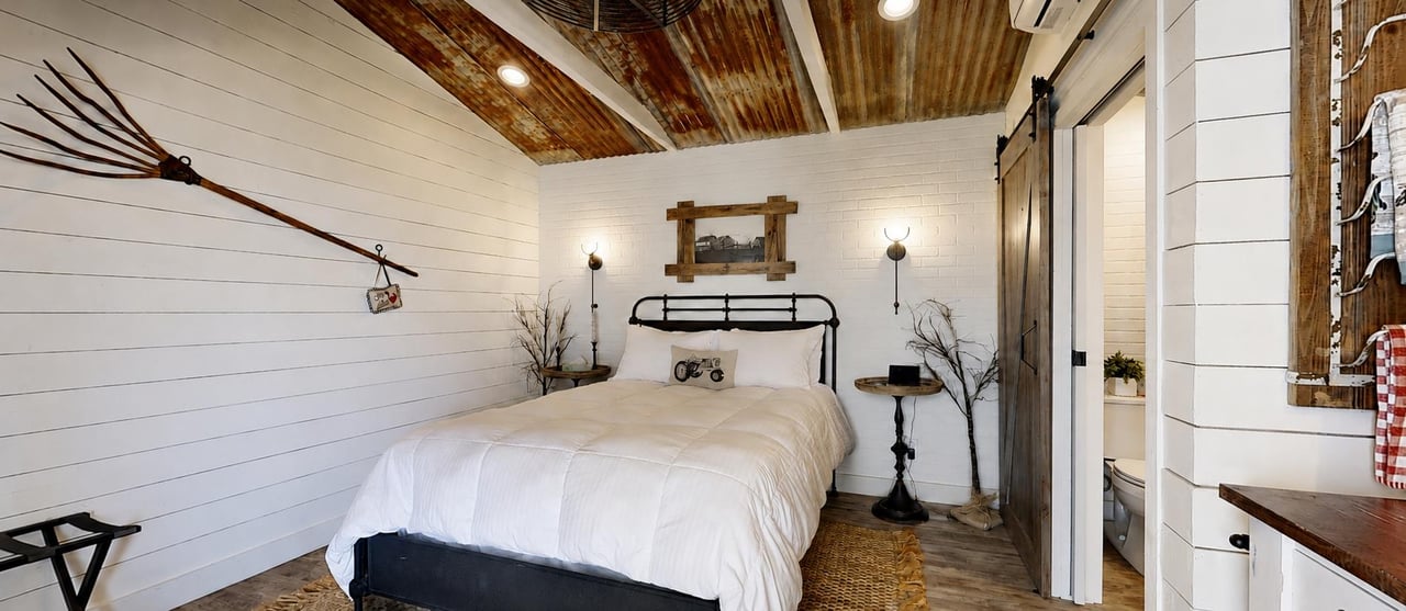 Distinctive detached guest suite with rusticinspired design, a corrugated metal ceiling, wet bar, sink, and coffee station.