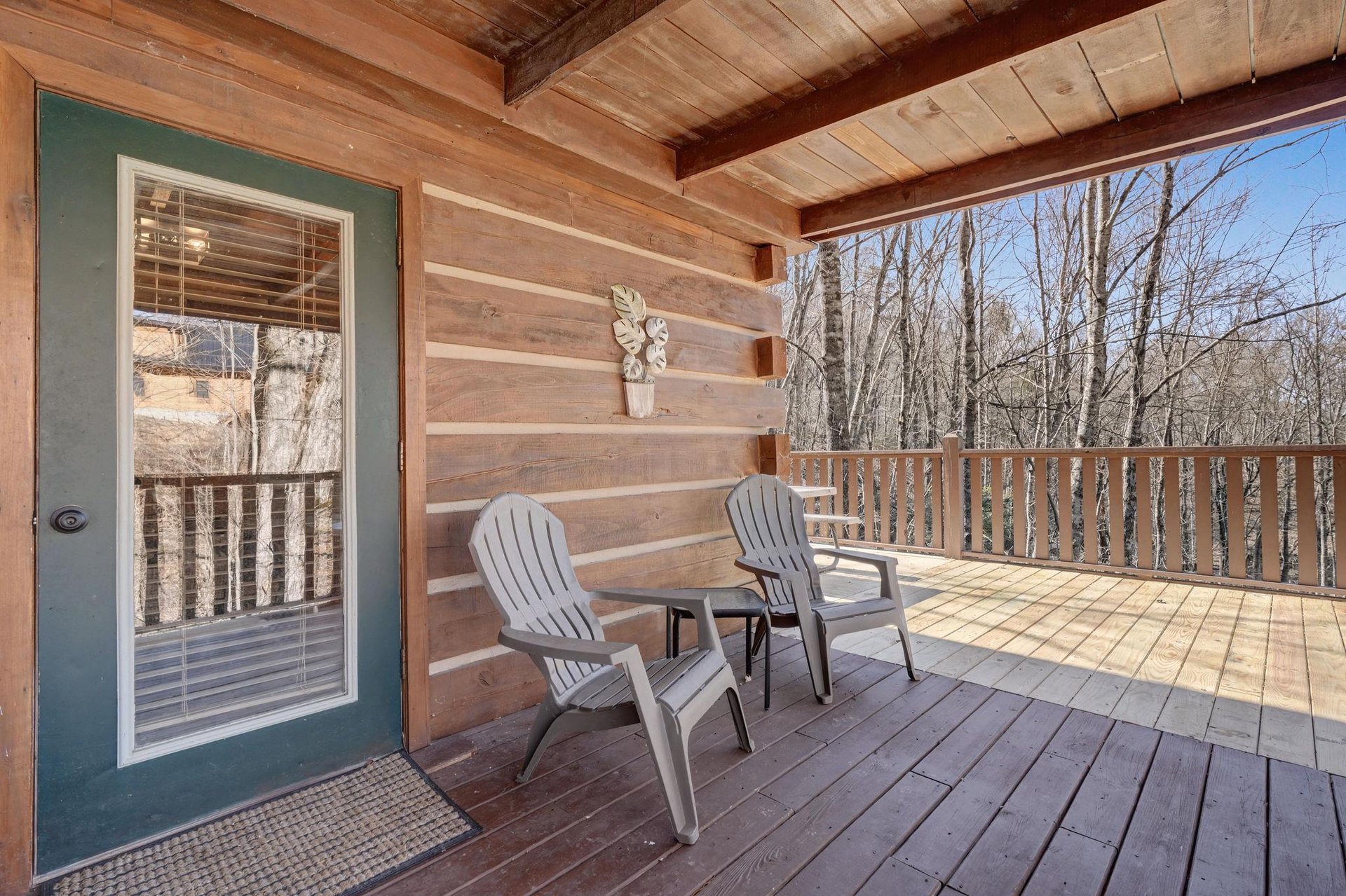 Step onto your private deck where morning coffee awaits among the treetops, with Adirondack chairs perfectly positioned for peaceful forest views.