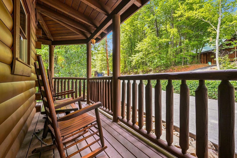 Step onto your private covered porch and settle into the rocking chairs, surrounded by lush summer greenery—a perfect spot to unwind and soak in the mountain air.