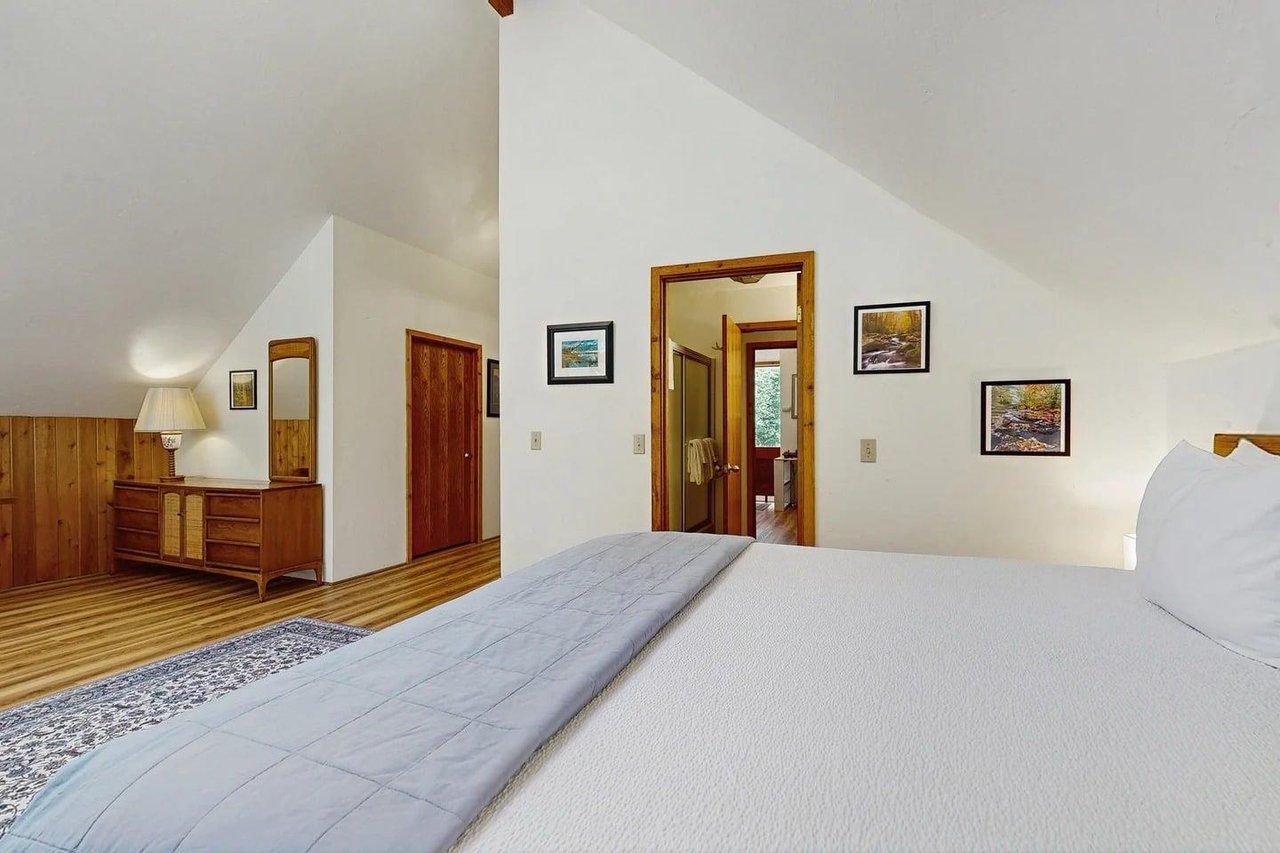 The primary bedroom continues with a dresser and space to spread out — a privatefeeling retreat that shares the upstairs bathroom with the second bedroom.
