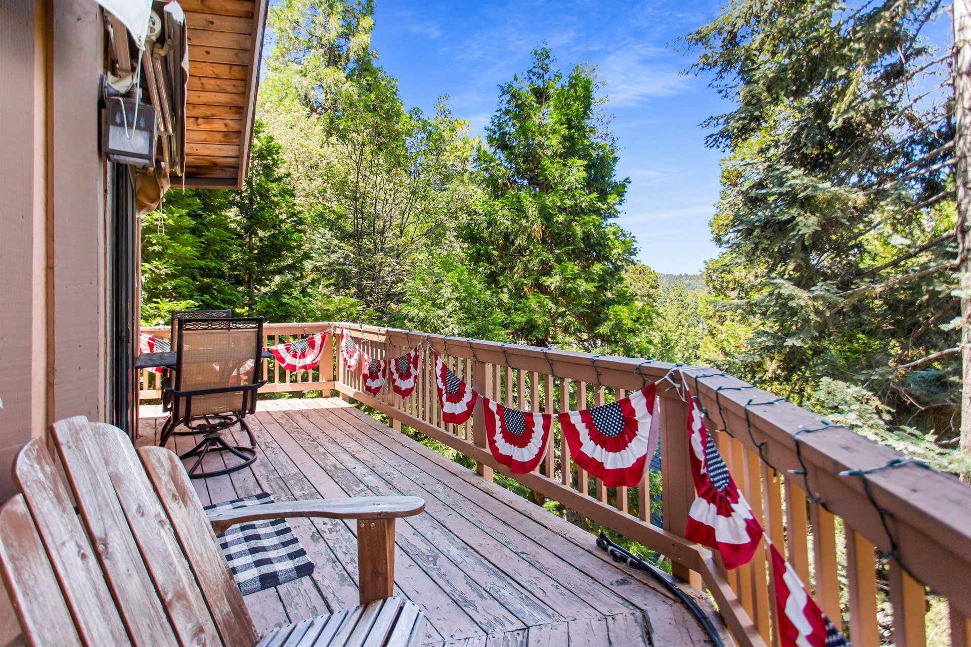 Spacious deck with treetop and lake views.