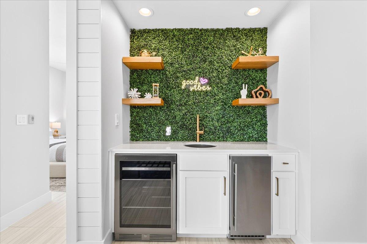 The game lounge wet bar features a beverage refrigerator and ice maker, offering a convenient space for entertaining and keeping refreshments close at hand.