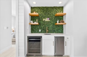The game lounge wet bar features a beverage refrigerator and ice maker, offering a convenient space for entertaining and keeping refreshments close at hand.