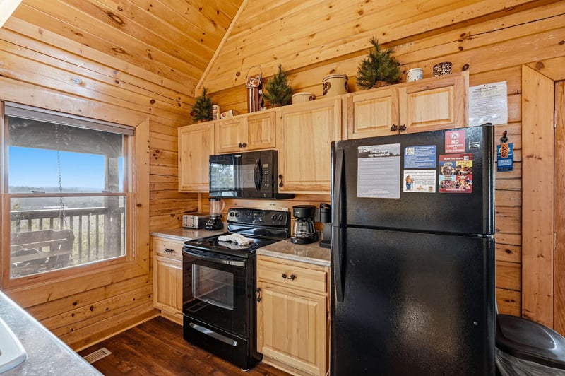 Your fully equipped kitchen features warm wood cabinets, modern appliances, and stunning views through the window while you cook.