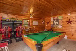 Pool table and driving arcade game in the game room at Hibernation Station, a 3bedroom cabin rental located in Pigeon Forge