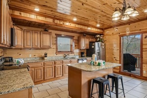 Your rustic mountain kitchen features granite counters, full appliances, and a cozy breakfast bar perfect for morning coffee together.