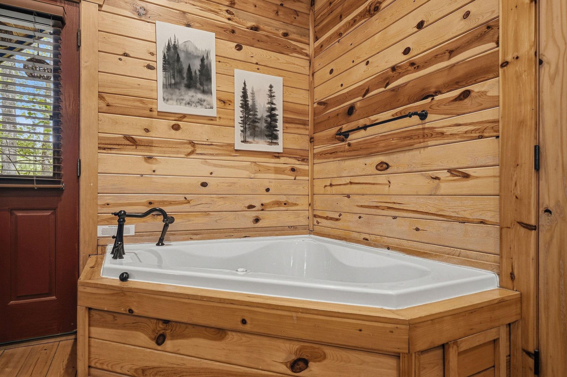 Soak away your stress in this luxurious corner tub, surrounded by warm wood walls and mountain artwork for the perfect cabin retreat.