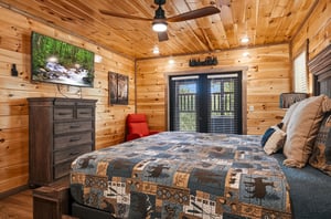 Drift off to sleep in your cozy cabin bedroom, surrounded by warm wood walls and rustic charm that makes every night feel like a mountain retreat.