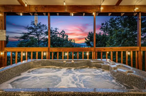 Unwind in your private hot tub as the sky bursts into vibrant pinks and oranges. Surrounded by lush forest, this serene mountain escape invites you to relax and soak in natures beauty.