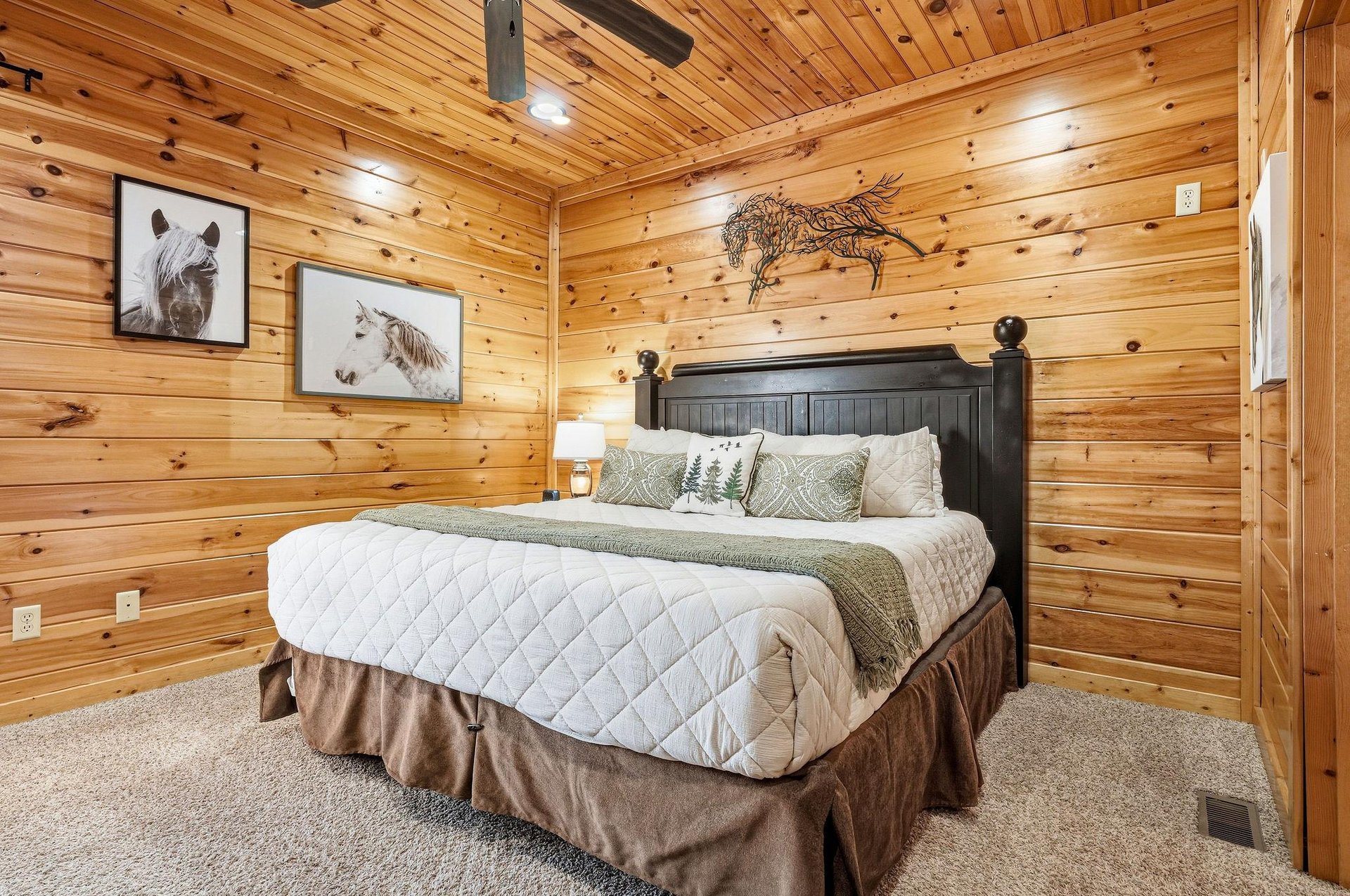 Drift off in your cozy rustic bedroom, surrounded by warm wood walls and charming horse artwork that creates the perfect mountain retreat atmosphere.