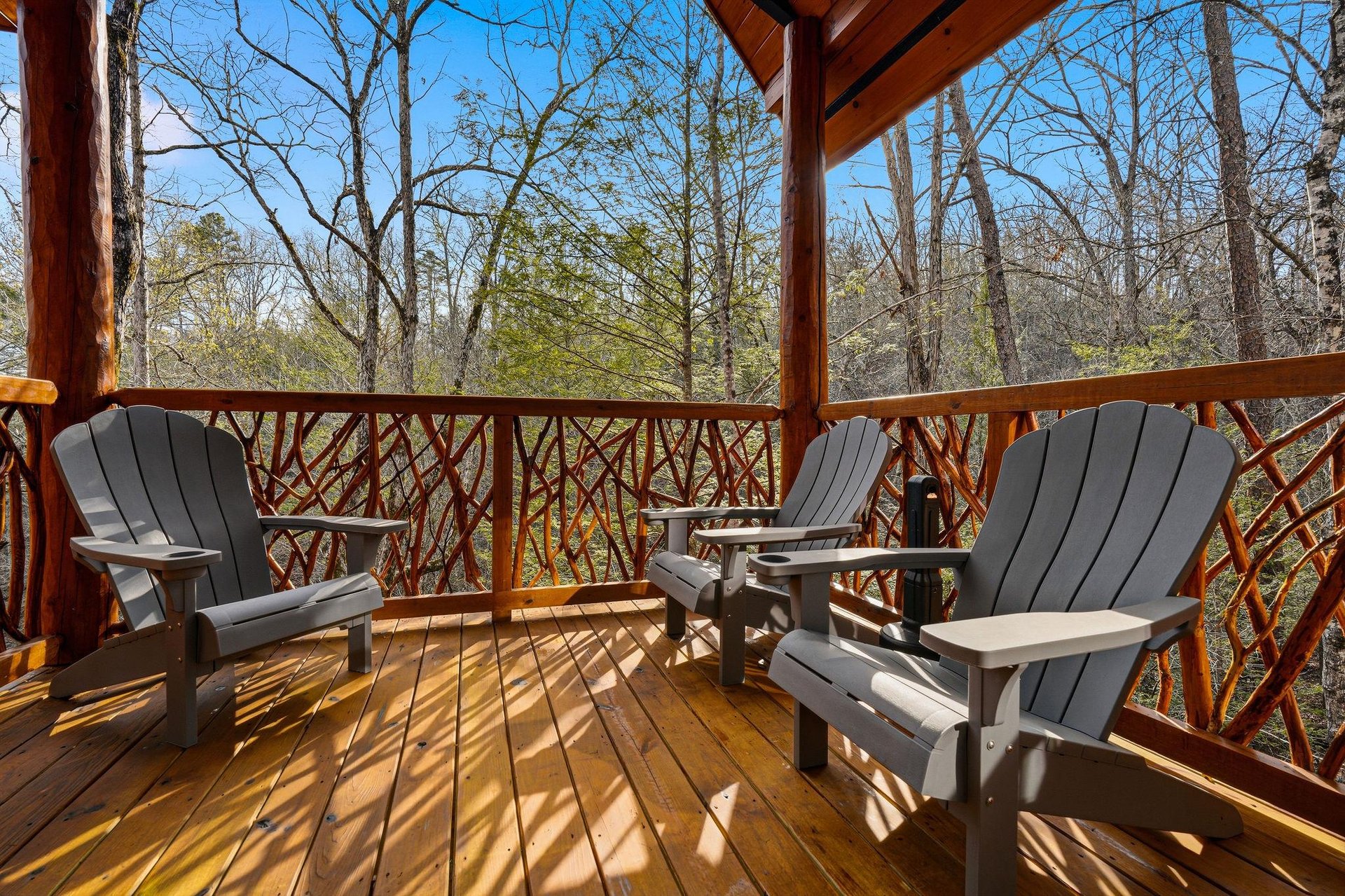 Unwind on your private covered deck with comfortable Adirondack chairs, surrounded by peaceful forest views that create the perfect retreat.