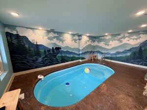 Dive into your private indoor pool surrounded by a stunning mountain mural that transforms your swim into a wilderness escape.