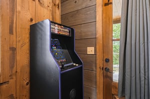 Challenge your travel companions to a retro arcade showdown with this classic game console, ready for friendly competition and nostalgic fun in your cozy cabin getaway.