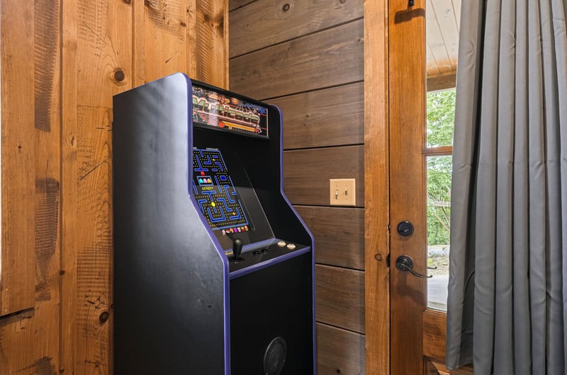 Challenge your travel companions to a retro arcade showdown with this classic game console, ready for friendly competition and nostalgic fun in your cozy cabin getaway.