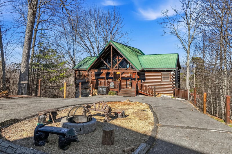 Rustic log cabin retreat with outdoor fire pit area surrounded by peaceful woodland setting.