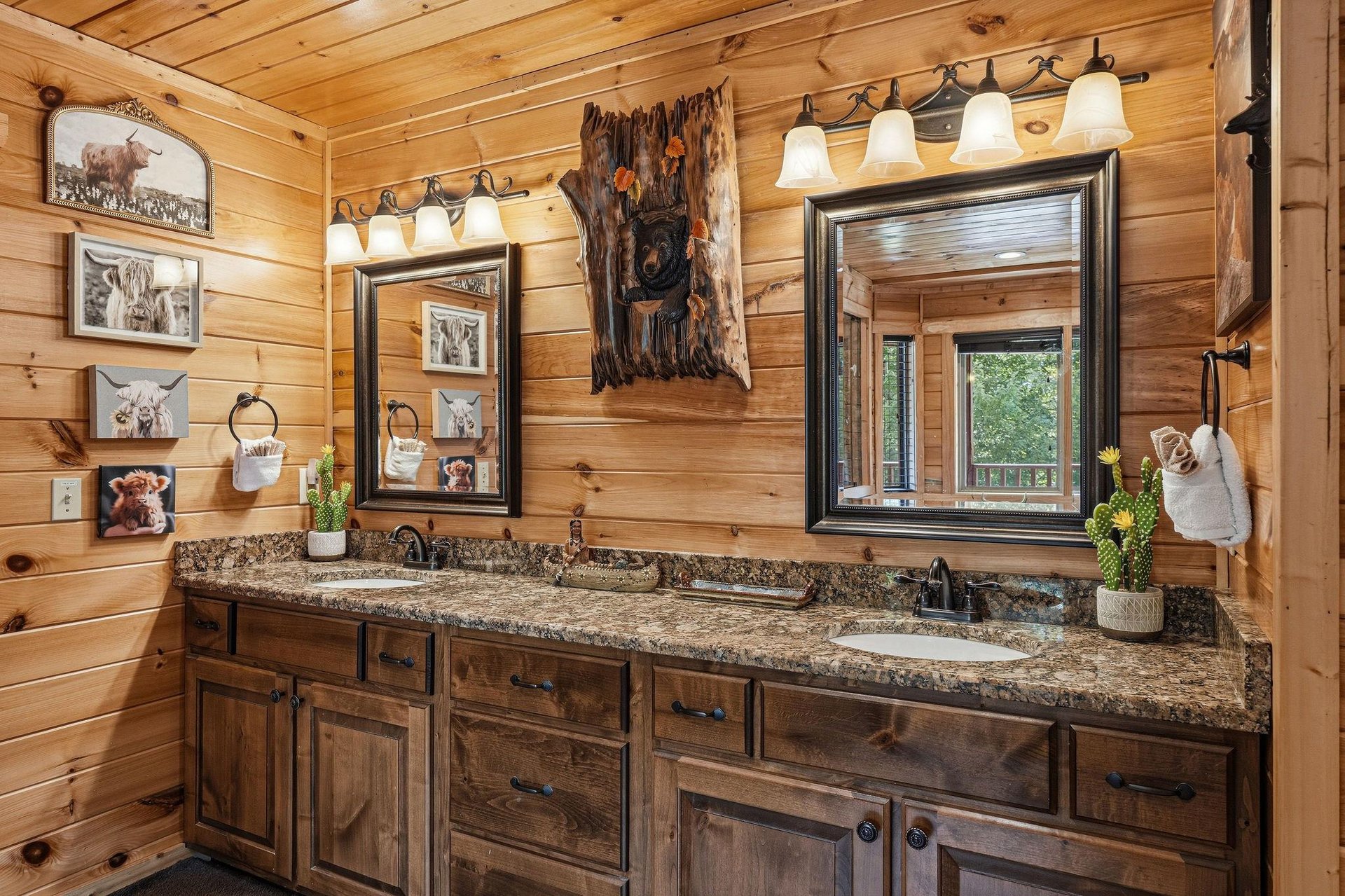 Your rustic bathroom features double vanities with granite countertops, framed mirrors, and charming woodlandthemed décor—a cozy retreat after your adventures.