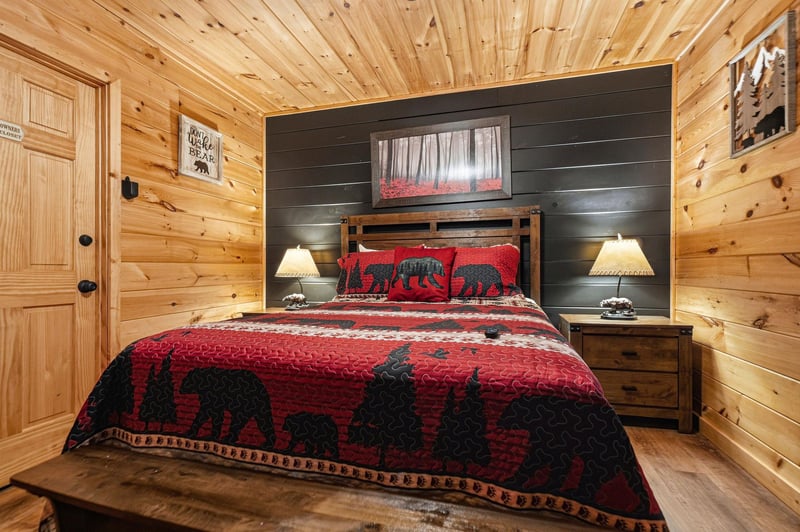 Sink into your cozy cabin retreat, where rustic warmth meets modern comfort beneath natural wood beams and soft bedside lighting, inviting you to unwind completely.