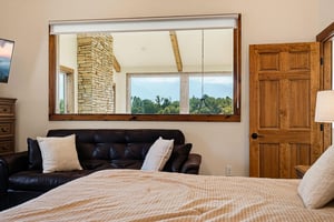 Your cozy retreat features a comfortable leather sofa and serene mountain vistas framing the horizon through the large windows.
