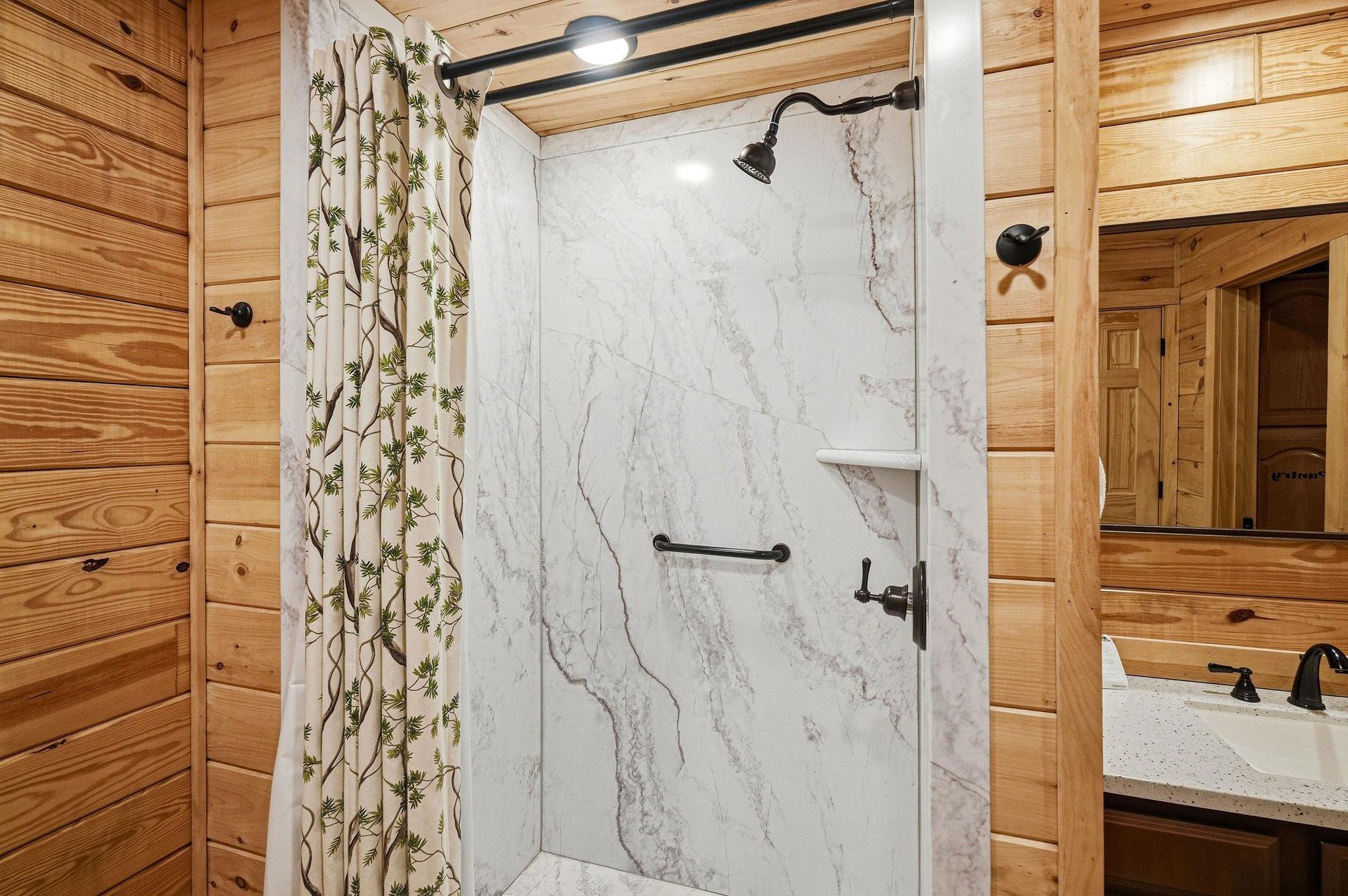 Step into your rusticelegant bathroom featuring marble shower walls and warm wood finishes for a serene retreat.