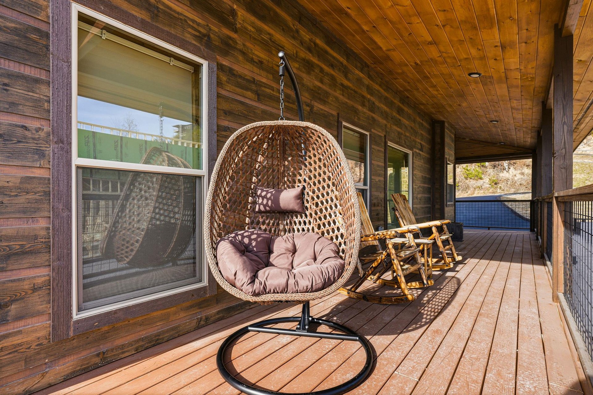 Unwind in your private hanging egg chair on the covered deck, surrounded by warm wood and peaceful views.