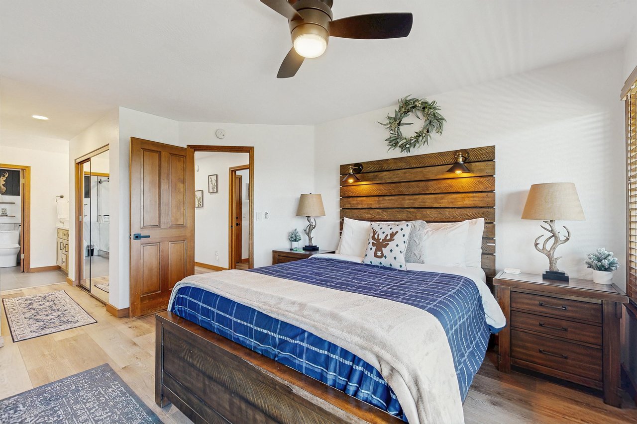 Features a king bed, fireplace, smart TV, deck access, and ensuite bathroom.