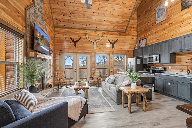 Relax in this stunning rustic cabin with soaring ceilings, stone fireplace, and open kitchen perfect for mountain getaways.