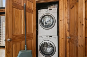 Your inunit laundry setup makes packing light effortless, with stacked washer and dryer tucked neatly behind beautiful wood cabinet doors.