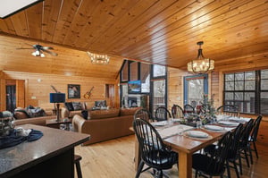 Gather around the rustic dining table while your group relaxes in the cozy living room, all warmed by beautiful wood paneling and natural light.