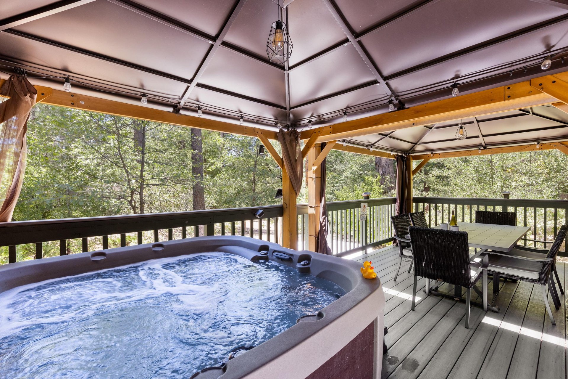 Private hot tub under the covered deck with plenty of outdoor seating too.