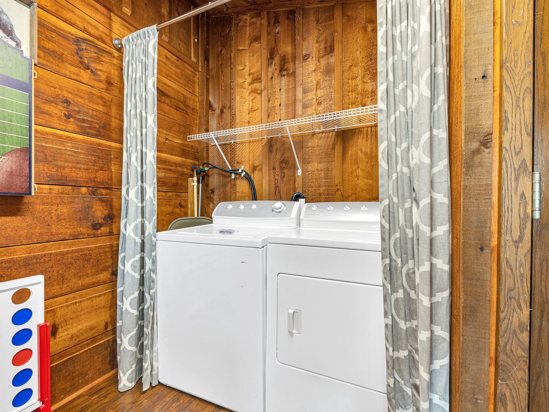 Your private laundry nook features fullsize washer and dryer with convenient shelving in warm wood surroundings.