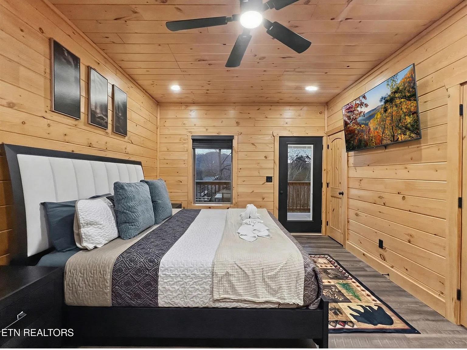 Sink into your cozy cabin bedroom where warm wood walls and crisp linens create the perfect mountain retreat for restful nights.