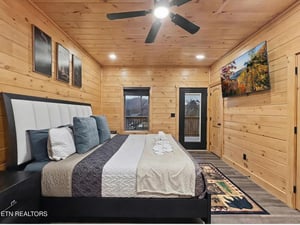 Sink into your cozy cabin bedroom where warm wood walls and crisp linens create the perfect mountain retreat for restful nights.
